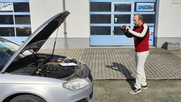Kfz-Gutachter Andreas Henschel fotografiert ein Fahrzeug