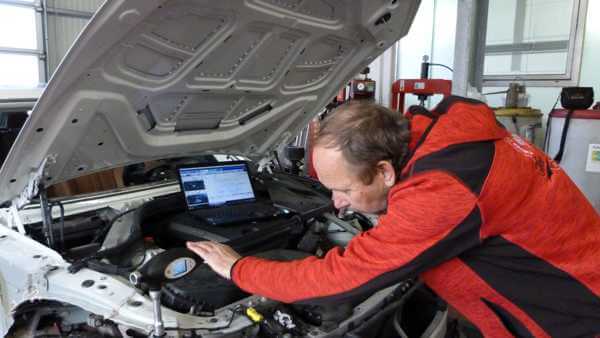 Kfz-Gutachter Andreas Henschel vermisst den Motorraum eines Fahrzeuges